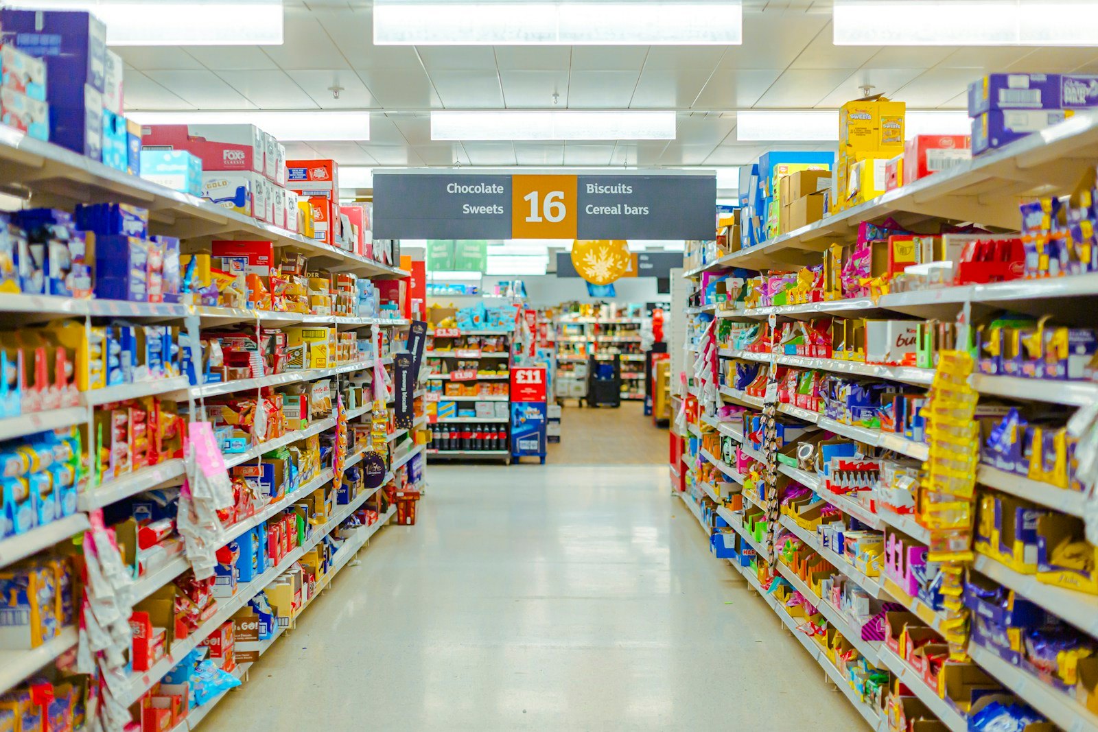 A grocery store aisle stocked with packaged snacks, biscuits and cereal bars